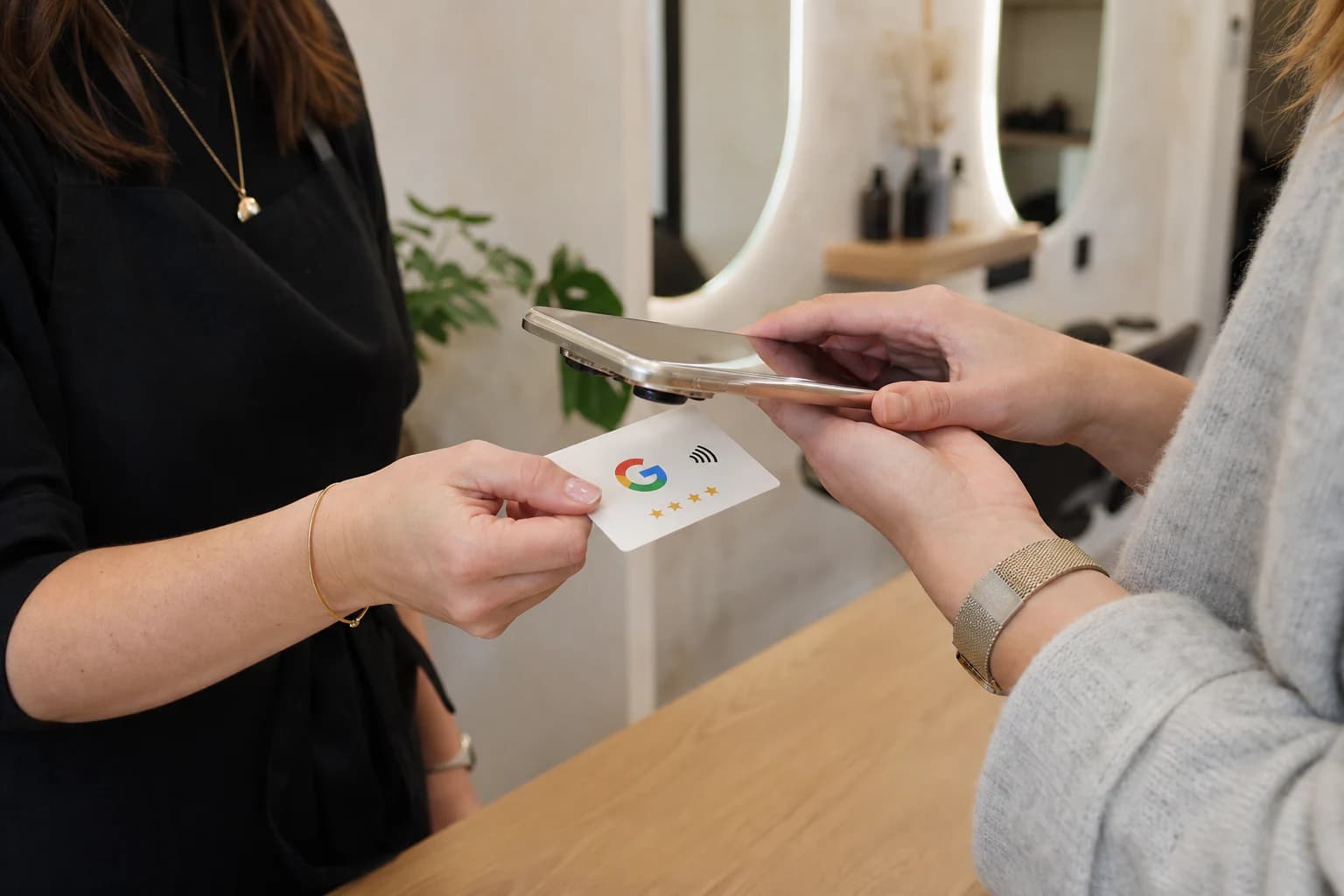 Une professionnelle présente la carte NFC au téléphone d’une cliente